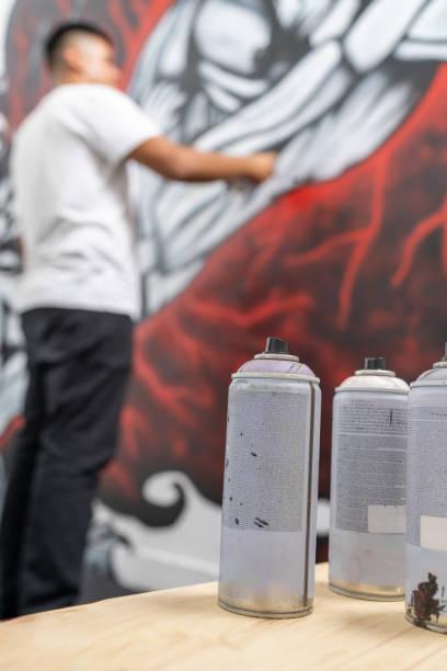 Street artist is creating a vibrant mural, using spray paint, adding a touch of urban art to a public space