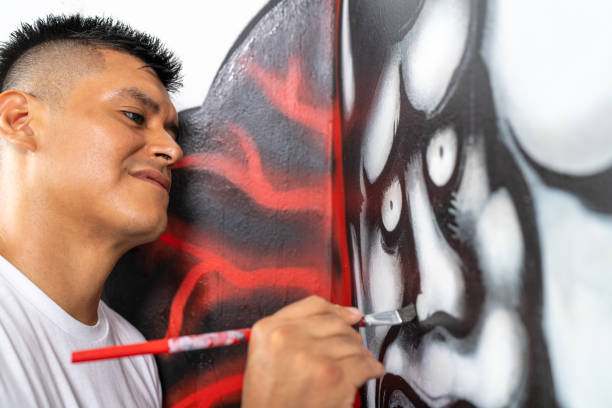 istock Latin artist painting a mural on a white wall 2191120175