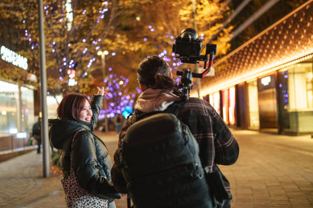 istock Camera operator man and woman walking in street after work. 2191120191