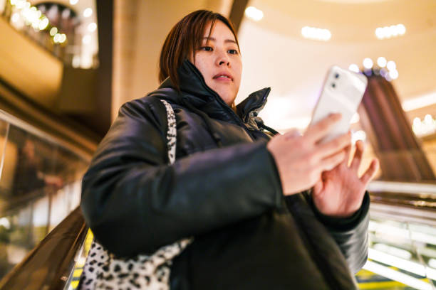 Woman using mobile phone in a shopping mall.