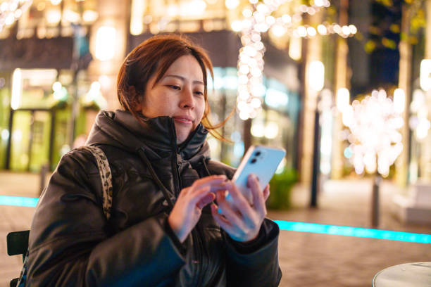 istock Woman using mobile phone in a sidewalk cafe in Tokyo. 2191121208
