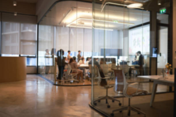 A professional woman engaging in her work with a digital tablet at a co-working space.