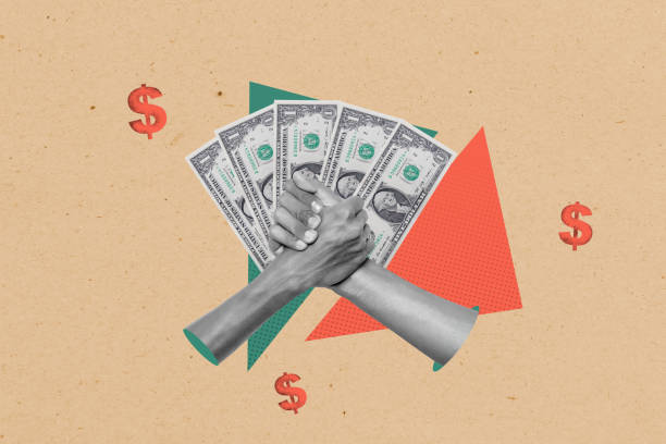 istock Two human hands with a gesture of a handshake agreement and dollar banknotes with dollar signs on a colored background 2191128435
