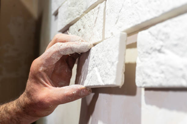 istock A hand is skillfully placing stone tiles onto a wall during a home improvement task 2191131993