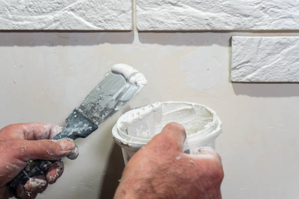 istock Skilled hands use a putty knife to apply paste on a textured wall during home renovation 2191132002