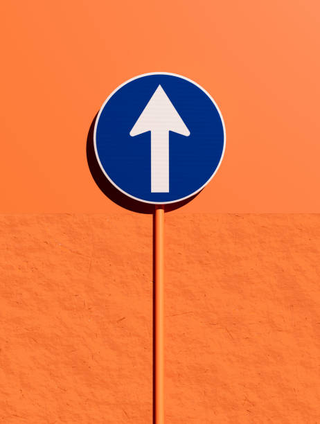 Mandatory traffic sign indicating the only permitted direction of travel is straight forward, mounted on a pole against an orange wall. 3D render