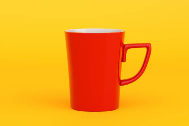istock Red mug standing on yellow background representing tea or coffee break 2191134575