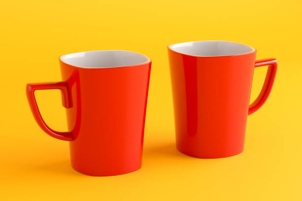 istock Two red mugs standing on yellow background representing couple or friendship 2191134714