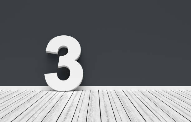 istock Number three leaning on dark gray wall in white room 2191134963