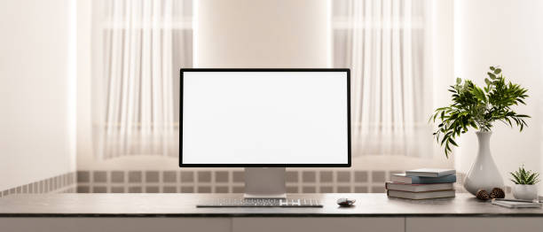 istock A computer with a white screen mockup and decor on a table in a minimalist and cozy room. 2191137012
