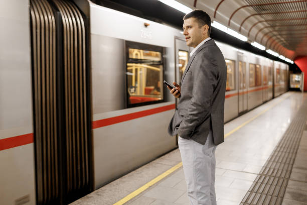 istock Businessman texting on mobile phone while waiting for train on subway station 2191137336