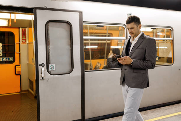 istock Businessman texting on mobile phone while waiting for train on subway station 2191137566