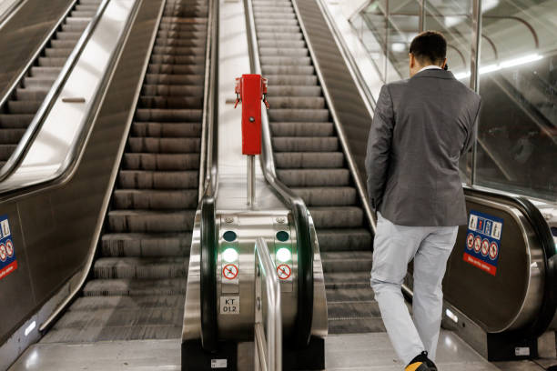 Businessman talking on mobile phone while leaving subway station