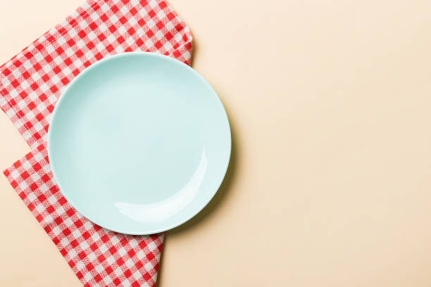 istock Top view on colored background empty round blue plate on tablecloth for food. Empty dish on napkin with space for your design 2191140826