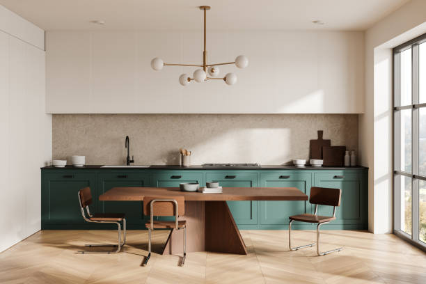 istock Stylish home kitchen interior with cooking cabinet, dining table near window 2191141691
