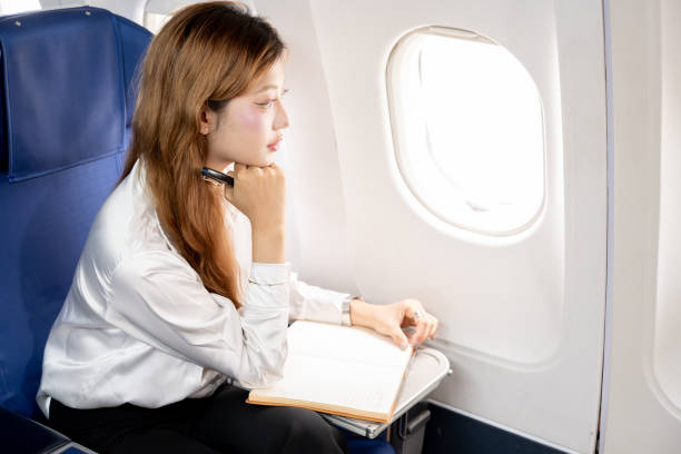 istock Asian businesswoman working during flight, taking notes in book 2191143489
