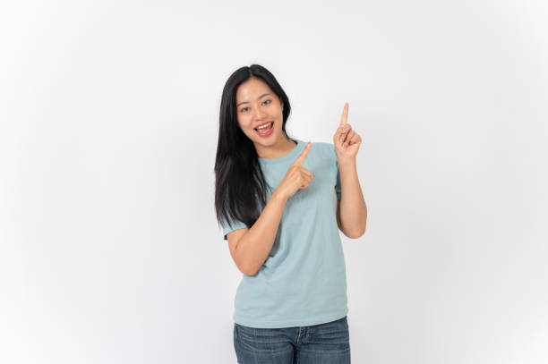 istock A beautiful Asian woman on a studio background, pointing her finger up as she recommend something. 2191146368