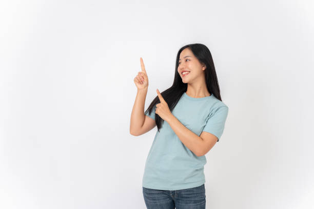 istock A beautiful Asian woman on a studio background, pointing her finger up as she recommend something. 2191146372