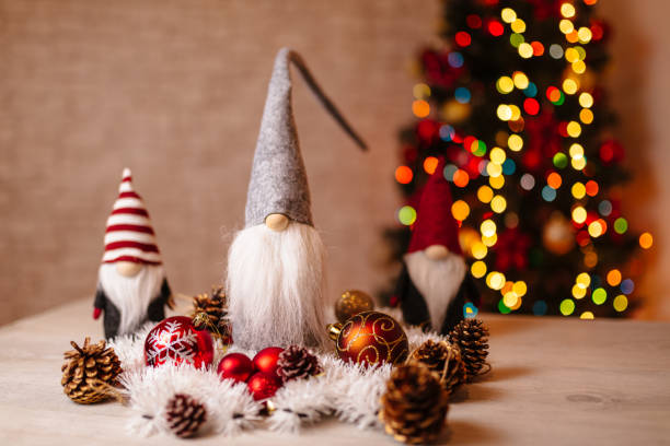 istock Festive Christmas Gnome Decorations with Ornaments and Bokeh Christmas Tree in Background 2191150511