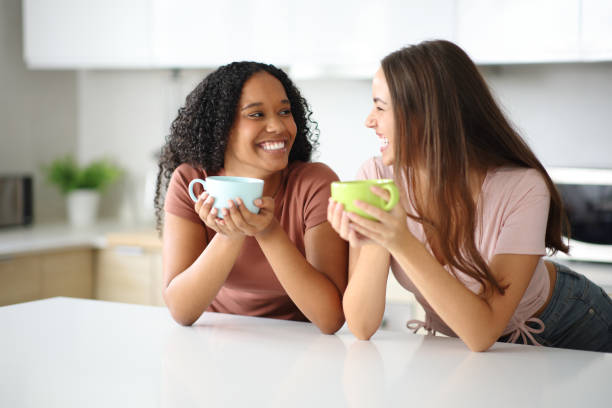 istock Two happy women talking and drinking in the kitchen 2191150883