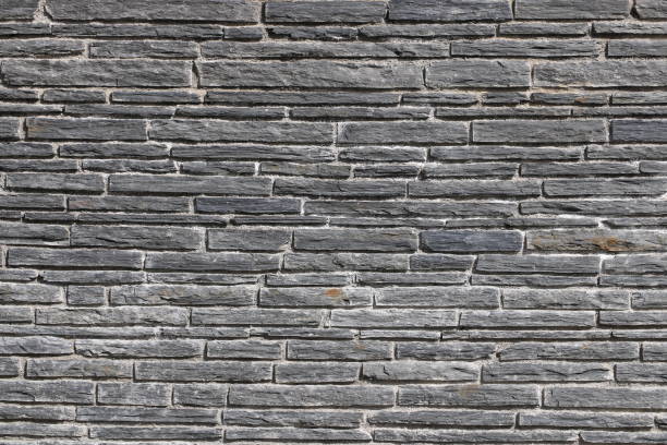istock Stacked stone brick wall. Stone cladding wall made of natural grey rocks 2191152520