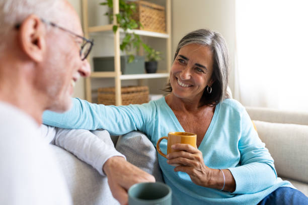 istock Happy senior couple relaxing on sofa, drinking coffee and chatting at home 2191152731