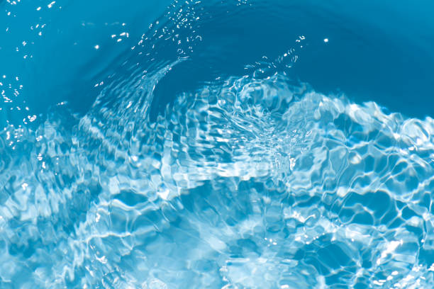 istock Blue water with ripples on the surface. Defocus blurred transparent blue colored clear calm water surface texture with splashes and bubbles. Water waves with shining pattern texture background. 2191153890
