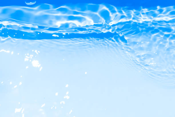 istock Blue water with ripples on the surface. Defocus blurred transparent blue colored clear calm water surface texture with splashes and bubbles. Water waves with shining pattern texture background. 2191154047