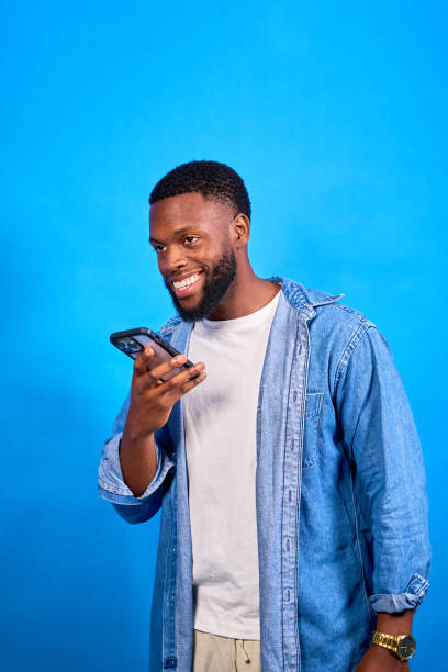istock Young man recording voice message on smartphone with blue background 2191156988