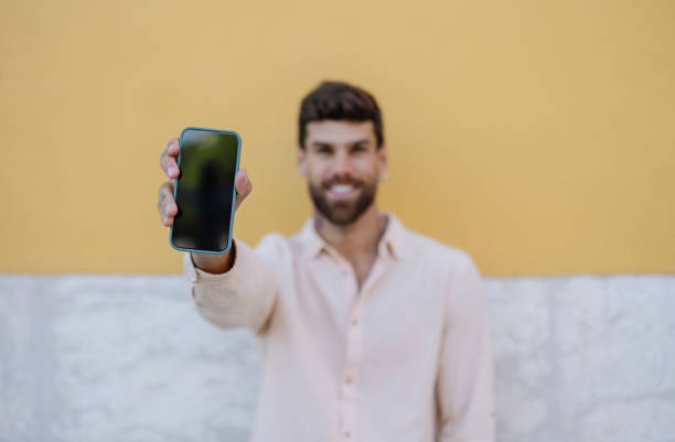 istock Young man showing smartphone with empty screen in portugal 2191160292