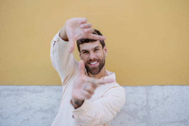 istock Young man framing face with hands and smiling at camera in portugal 2191160297