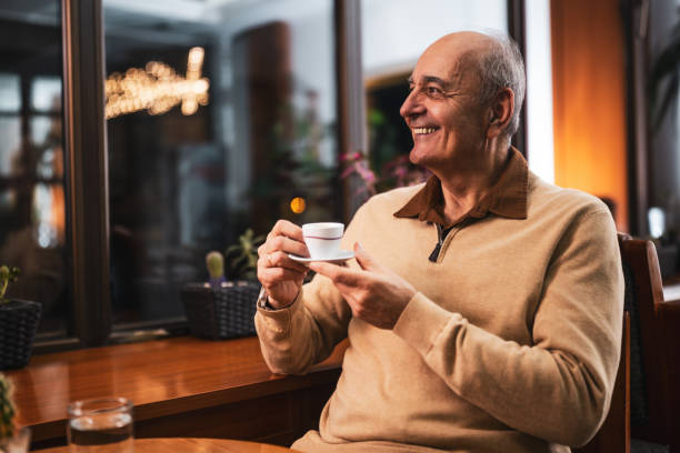 istock Cheerful senior man drinking coffee in city cafe 2191160528