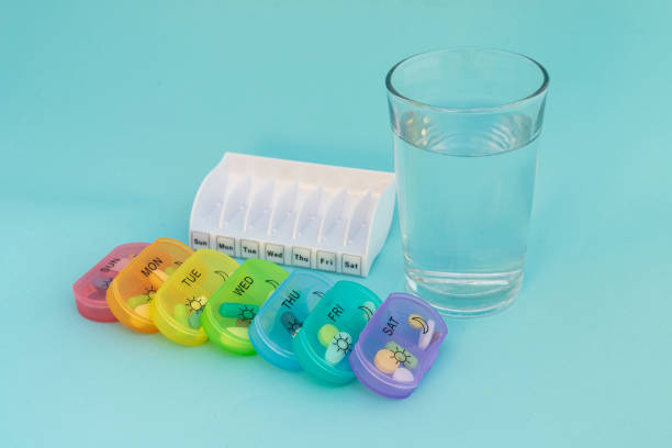 istock 7 day pill organizer with a glass of water 2191160987