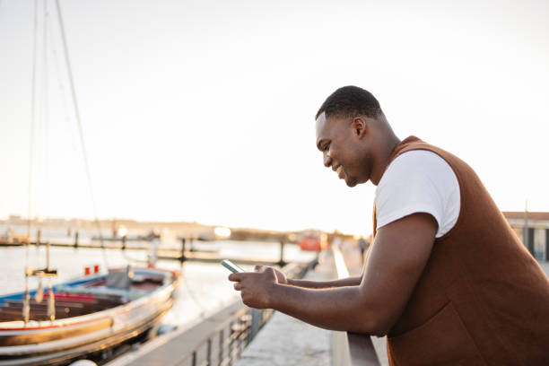 istock Tourist using smartphone in lisbon harbor at sunset 2191161498