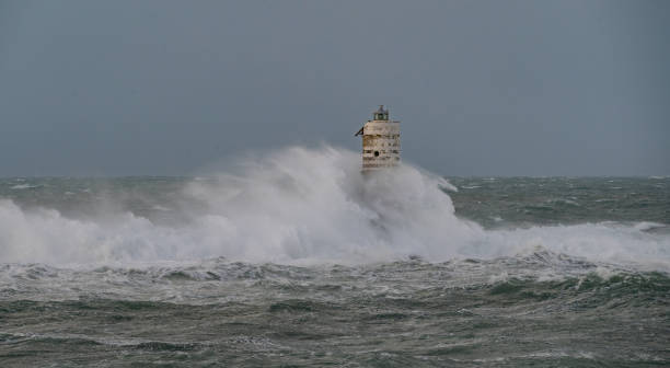 istock white and black lighthouse standing in rough sea during storm 2191162510