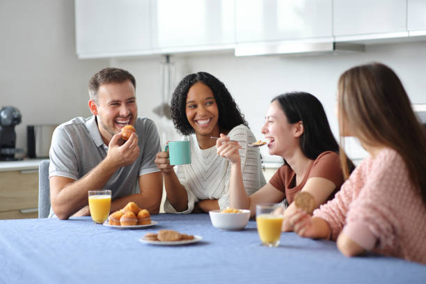 istock Happy interracial friends at breakfast talking in the kitchen 2191165396