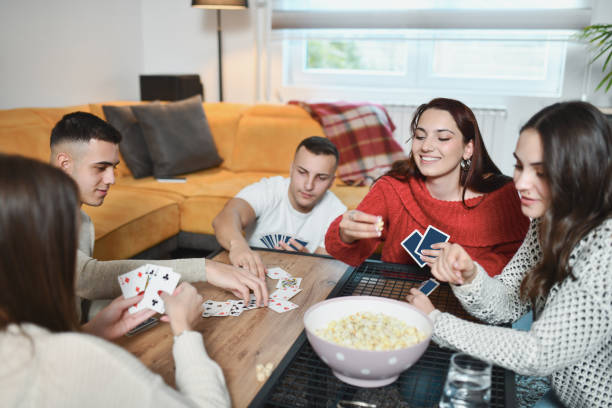 istock Diverse Friend Group Playing Card Games and Snacking on Popcorn 2191169757