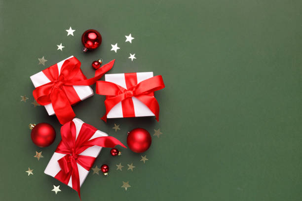 istock Christmas holiday background. Gift boxes and red decorations on color background 2191172650