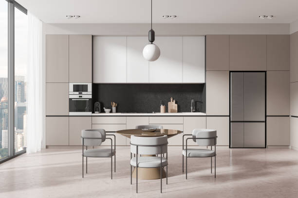 istock Modern kitchen with sleek cabinetry, dining table and chairs, and a large window with a city view. 3D Rendering 2191175811