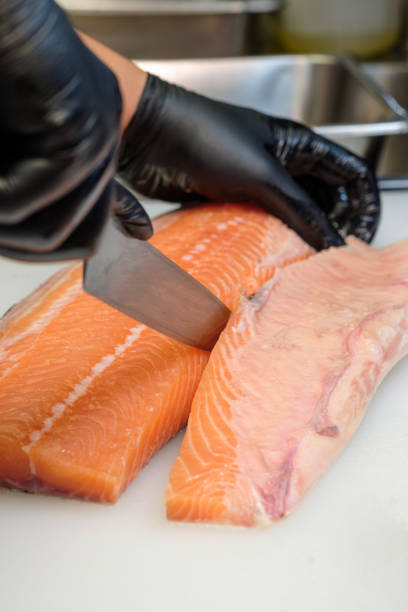 istock Chef's Hands Wear black gloves Slicing Salmon. 2191182155