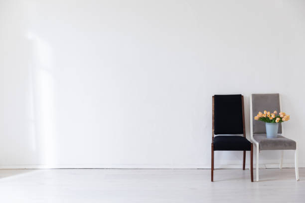 istock Two multicolored chairs in the interior of an empty white room 2191182289
