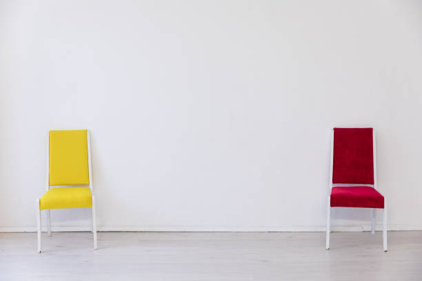 Two multicolored chairs in the interior of an empty white room