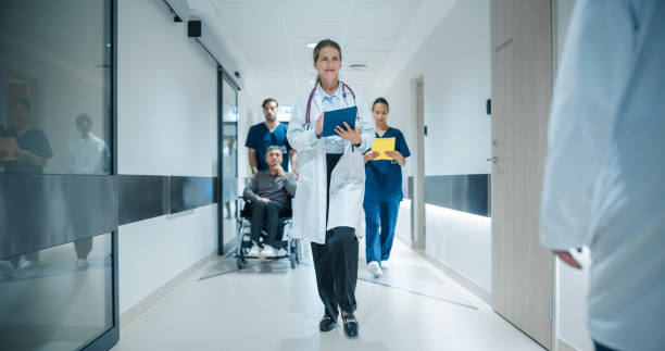 istock Portrait of a Female General Practitioner Using Tablet Computer to as She is Walking and Browsing Insights About a Complex Case. Healthcare Workers Walking Through a Modern Hospital Corridor 2191184015