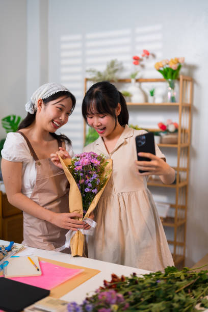 istock Two florists taking a selfie with a beautifully arranged bouquet, celebrating teamwork and creativity in a vibrant flower shop 2191184133