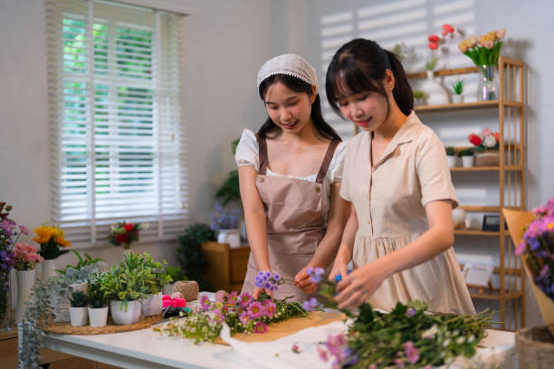 istock Two florists sharing a joyful moment while arranging flowers in a vibrant and organized workspace filled with colorful blooms 2191184148