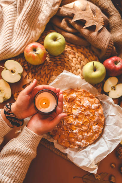 istock A cozy autumn setup featuring a freshly baked apple pie surrounded by apples, walnuts, a candle, and a warm drink 2191184643