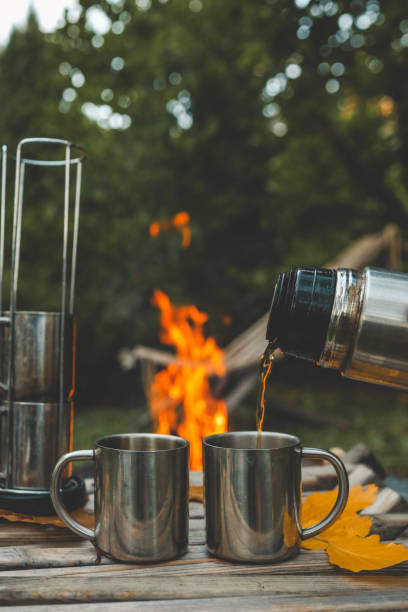 istock Themed trip. The man pours a hot drink into the thermos 2191184795