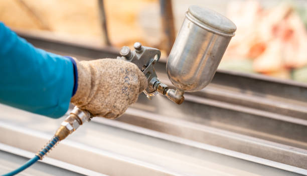 istock Construction worker painting metal structure surface coating with a spray gun at construction site. Metal corrosion and rust protection. Industrial precision. Protective coating to a metal structure. 2191185615