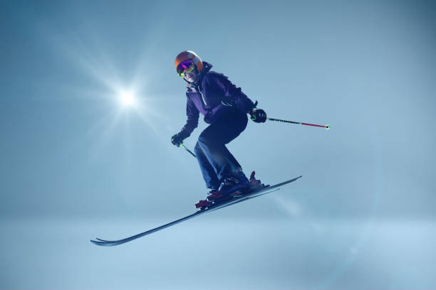 Flight moment of a ski jumper over the snow hill, skier in the air. Soaring through the sky concept.