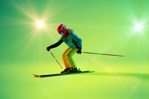 istock Athletic woman, kier bends into sharp turn against glowing green backdrop. Colorful illumination enhances action's energy. 2191186921